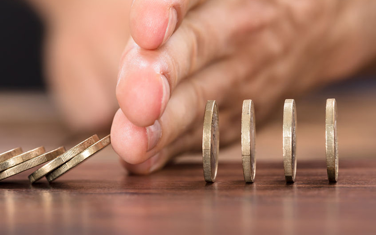 Hand Protecting Coins From Falling While Playing Domino