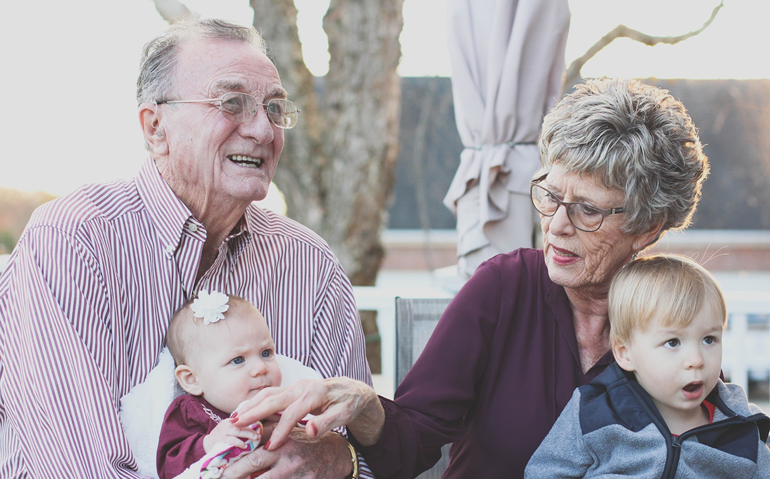 Grandmother and Grandfather Holding Child on Their Lap