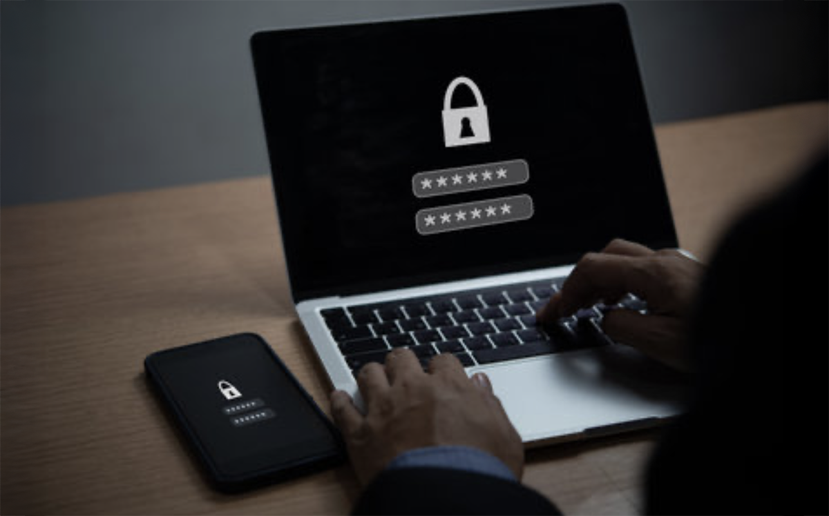 Person entering password on laptop and smartphone with digital lock icons, symbolizing cybersecurity and account protection after 16 billion credentials data breach