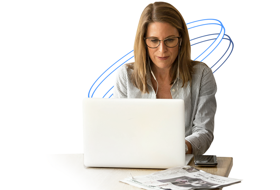 Woman learning about financial literacy on a laptop with a newspaper and smartphone on the table